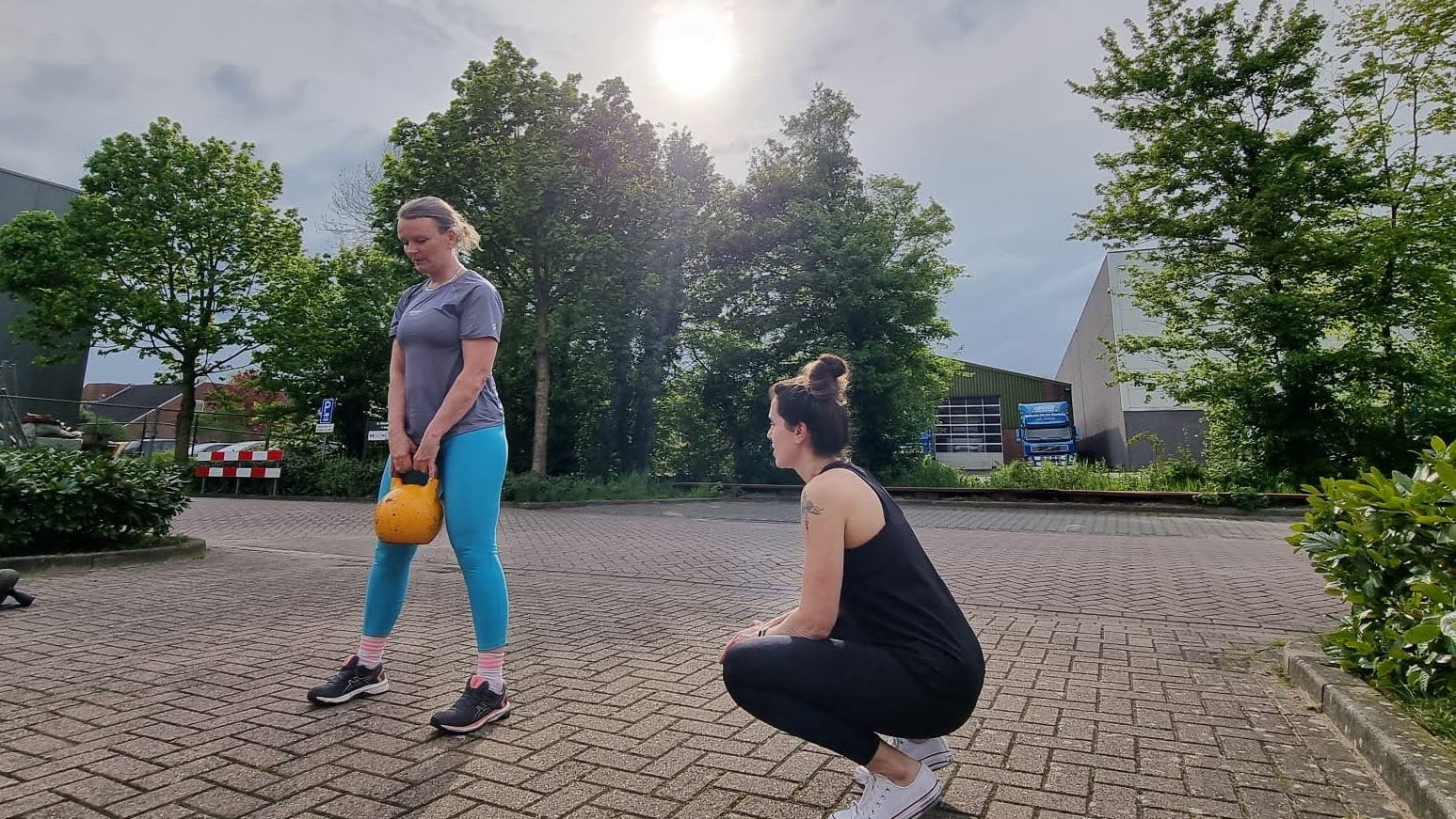 Khadija coacht een klant tijdens een 1-op-1 krachttraining buiten